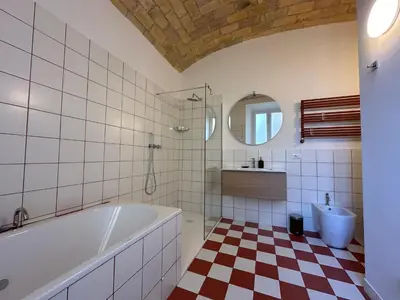 a bathroom with a tub and a sink and a mirror at Santamaura Vatican Apartment in Rome
