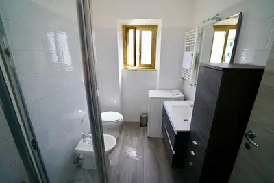 a white bathroom with a toilet and a sink at (9)Nine stops from the Colosseum in Rome