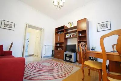 a living room with a desk and a red chair at Casa Anna a Roma in Rome