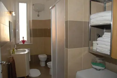a bathroom with a sink and a toilet and towels at Casa Anna a Roma in Rome