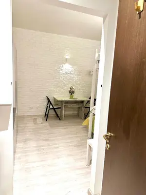 a dining room with a table and a white brick wall at Rome Apartment Marconi in Rome