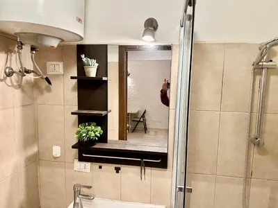 a person taking a picture of a mirror in a bathroom at Rome Apartment Marconi in Rome