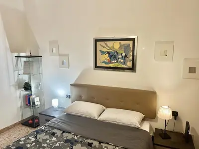 a bedroom with a bed and a painting on the wall at Cuore di Marconi Apartment in Rome