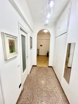 an empty hallway with white walls and a hallway with a door at Cuore di Marconi Apartment in Rome