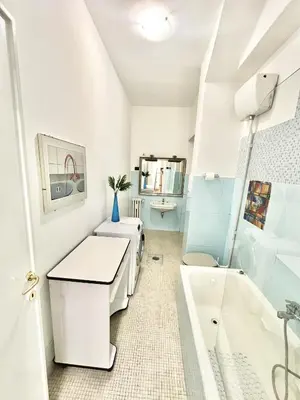 a white bathroom with a sink and a tub at Cuore di Marconi Apartment in Rome
