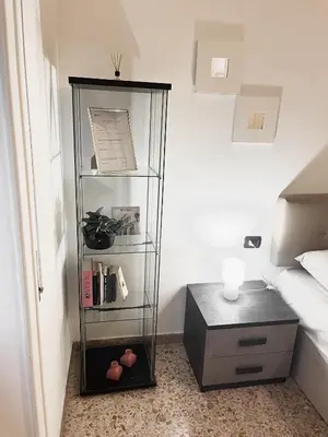 a room with a book shelf next to a bed at Cuore di Marconi Apartment in Rome