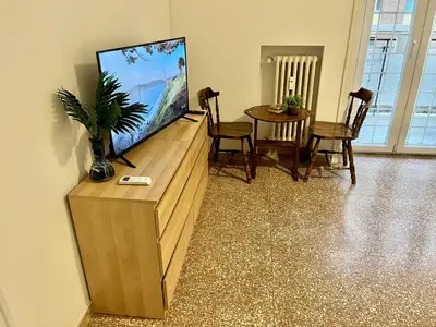 a living room with a flat screen tv and a table at Cuore di Marconi Apartment in Rome