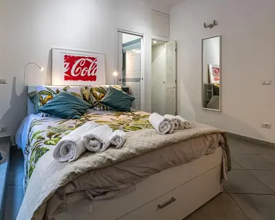 a cocacola sign above a bed with towels on it at Belle Arti home in Rome