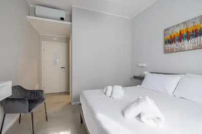a bedroom with a white bed with towels on it at Belli Suites Vatican Rome Guest House in Rome