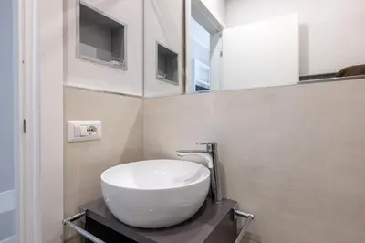 a bathroom with a white sink and a mirror at Belli Suites Vatican Rome Guest House in Rome
