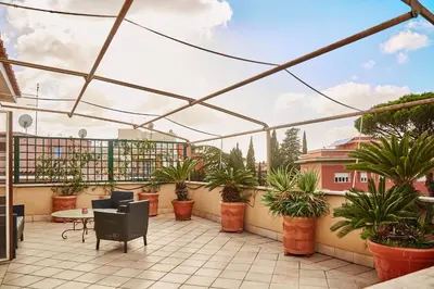 a patio with potted plants and a glass roof at Monteverde Suite Apartment in Rome