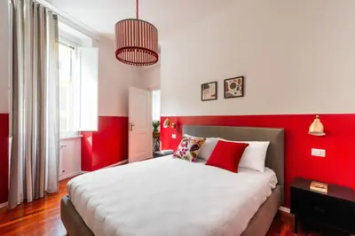 a red bedroom with a large bed with red walls at Mecenate Suite Colosseum in Rome