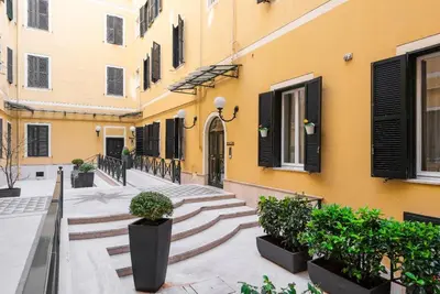 a courtyard of a building with stairs and plants at Mecenate Suite Colosseum in Rome