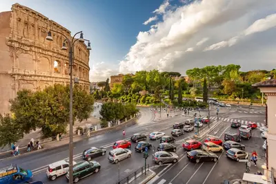 a busy city street filled with lots of cars at Iconic apartment with unique Colosseum view in Rome