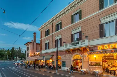 a building on a street with people walking in front of it at Iconic apartment with unique Colosseum view in Rome