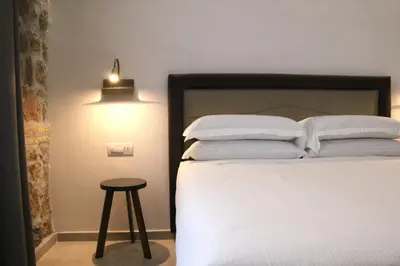 a bedroom with a bed with a stool next to it at Joyful 148 Luxury Guest House in Rome