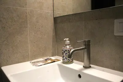 a bathroom sink with a soap dispenser on it at Joyful 148 Luxury Guest House in Rome