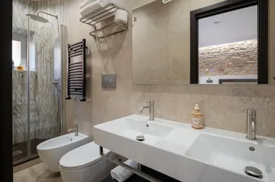 a bathroom with a sink and a toilet and a mirror at Joyful 148 Luxury Guest House in Rome