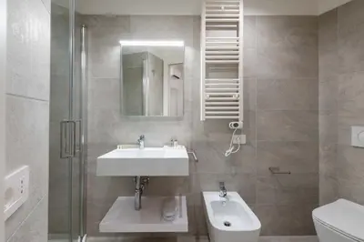 a bathroom with a sink and a toilet and a mirror at ELICAL Vatican Suites in Rome
