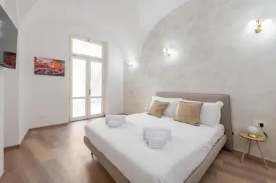 a white bedroom with a large bed with white walls at ELICAL Vatican Suites in Rome