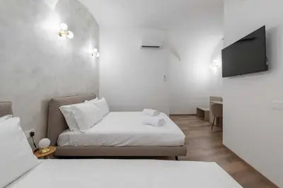 a small room with a bed and a tv at ELICAL Vatican Suites in Rome