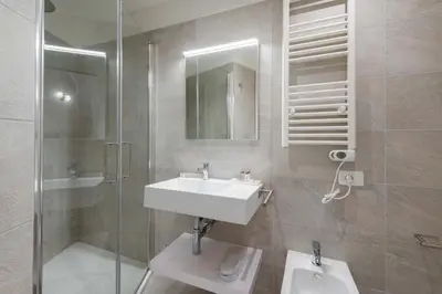 a bathroom with a sink and a shower and a mirror at ELICAL Vatican Suites in Rome