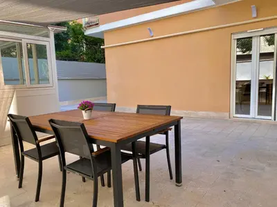 a wooden table and chairs in front of a house at Domus Carola in Rome