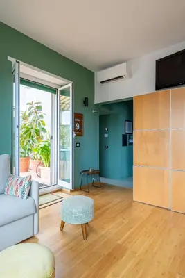 a living room with green walls and a couch at Spacious with terrace 3 bedroom, metroA Battistini in Rome