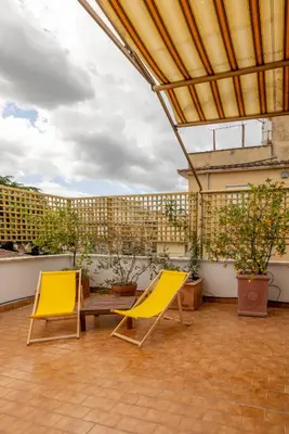 two yellow chairs on a balcony with plants at Spacious with terrace 3 bedroom, metroA Battistini in Rome