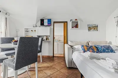 a bedroom with a large bed and a dining room at Vatican Borgo Gem Stay in Rome
