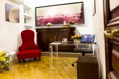 a room with a glass table and a red chair at LaHouse Rome by Premium Suites Collection in Rome