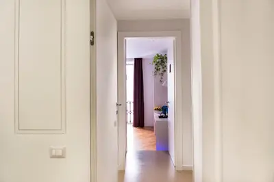 a hallway with white walls and an open door at LaHouse Rome by Premium Suites Collection in Rome