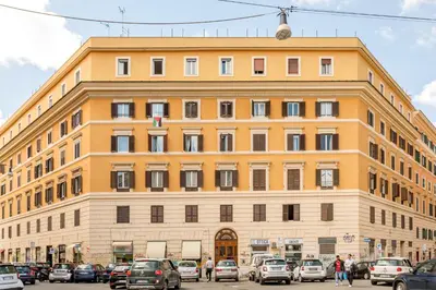a large building with cars parked in a parking lot at Sanniti Loft San Lorenzo in Rome