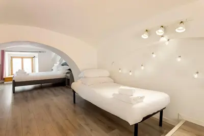 a white room with two beds and a couch at Sanniti Loft San Lorenzo in Rome