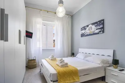 a white bedroom with a bed with towels on it at ArtStay AC Apt Near Metro, Fiumicino Airport in Rome
