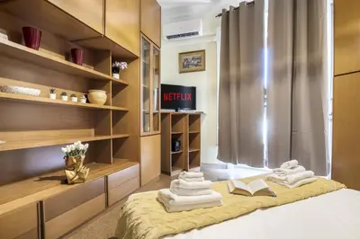 a room with a bed with towels and books at ArtStay AC Apt Near Metro, Fiumicino Airport in Rome