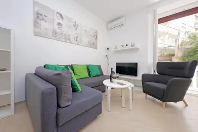 a living room with a couch and two chairs and a tv at Livorno by Halldis in Rome