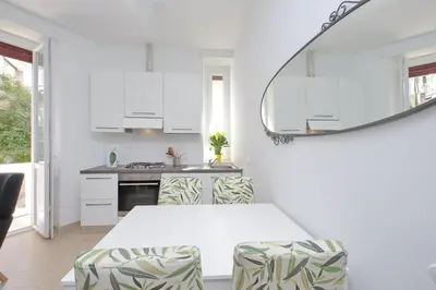 a kitchen with white cabinets and a table and chairs at Livorno by Halldis in Rome