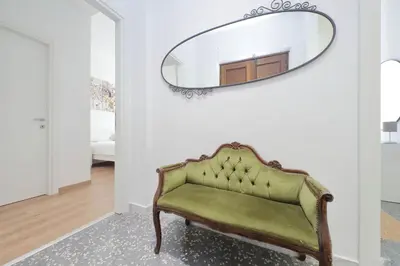 a green couch in a hallway with a mirror at Livorno by Halldis in Rome
