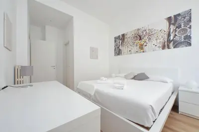 a white bedroom with two beds and a painting on the wall at Livorno by Halldis in Rome