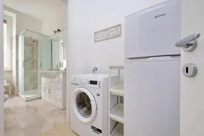 a white laundry room with a washer and dryer at Livorno by Halldis in Rome