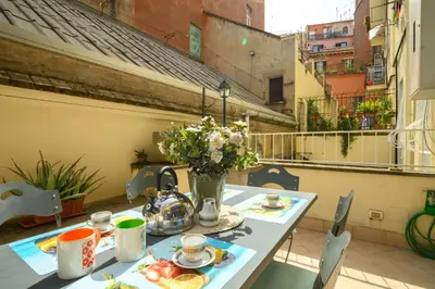 a table with a vase of flowers on a balcony at Quattro Cantoni Apartment Monti in Rome