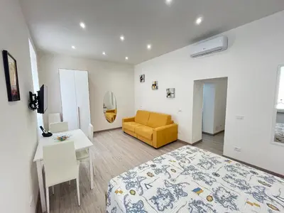 a bedroom with a bed and a table and a yellow chair at SpecchiamoR in Rome