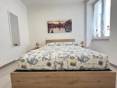 a bedroom with a bed with a blue and white comforter at SpecchiamoR in Rome