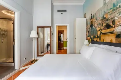 a bedroom with a large white bed with a painting on the wall at Fori Imperiali Luxe Mansion in Rome