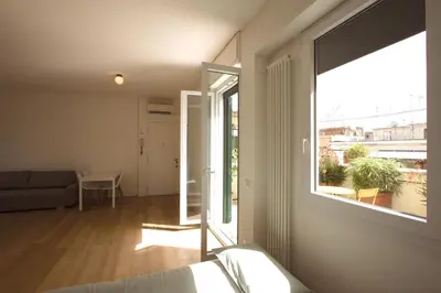 a living room with a couch and a large window at Statonia Terrace Penthouse in Rome