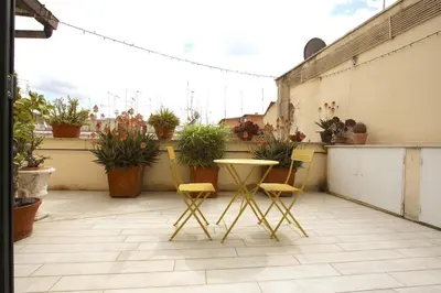 a patio with a table and chairs and potted plants at Statonia Terrace Penthouse in Rome