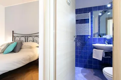 a blue tiled bathroom with a bed and a sink at Alchimia Friends and Family 3 bedrooms 3 bathrooms in Rome