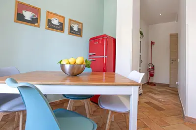 a dining room with a table and a red refrigerator at Alchimia Friends and Family 3 bedrooms 3 bathrooms in Rome
