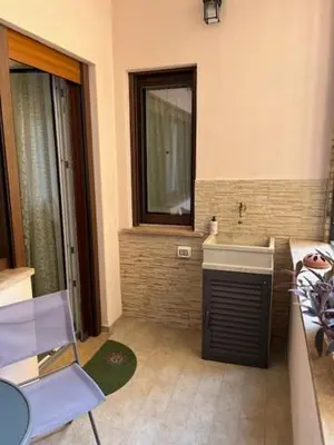a bathroom with a sink and a table and a chair at Casa Dalia in Rome